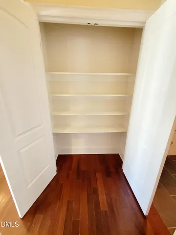 a view of walk in closet with empty racks