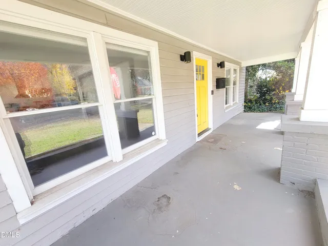 a view of empty room with wooden floor and windows