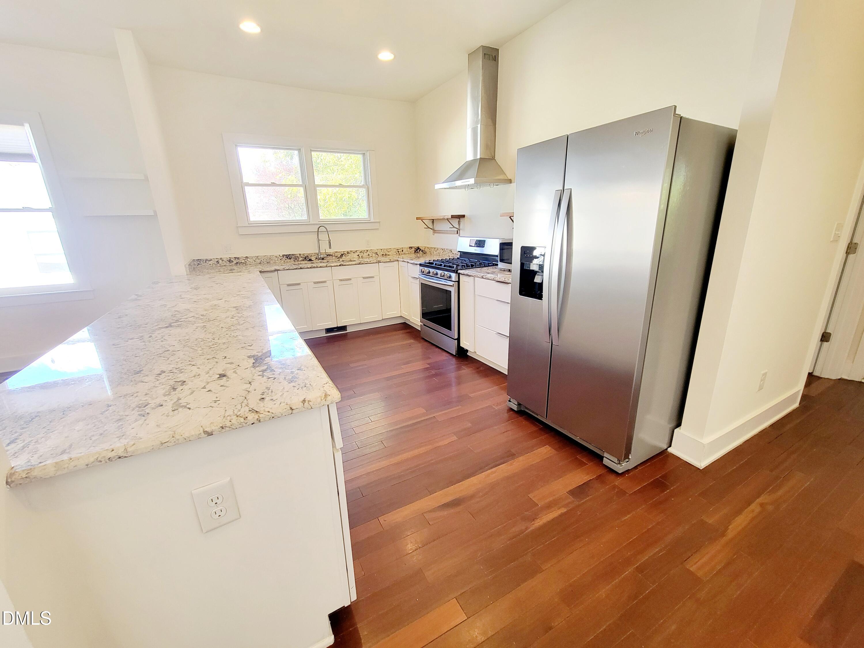 707 South East Street Raleigh, NC 27601 - Photo 10 of 46 a kitchen with granite countertop white cabinets and stainless steel appliances