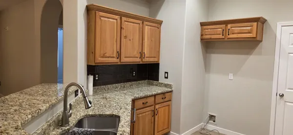 a kitchen with granite countertop a refrigerator stove and oven with wooden floor