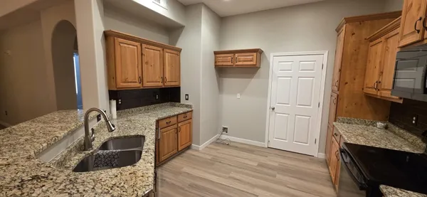 a kitchen with stainless steel appliances granite countertop a sink and a refrigerator
