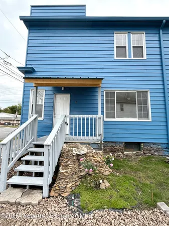 a view of a house with wooden floor and a small yard