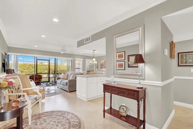 a living room with furniture a large window and kitchen view