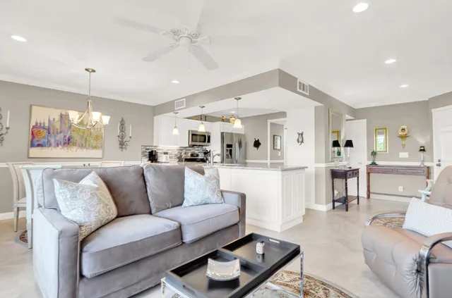 a living room with furniture kitchen view and a wooden floor