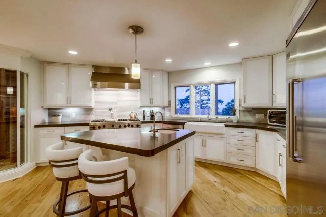 a kitchen with stainless steel appliances kitchen island granite countertop a table and chairs in it