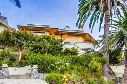 a backyard of a house with table and chairs under an umbrella