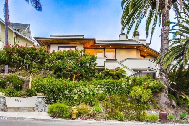a view of a yard with plants and wooden fence