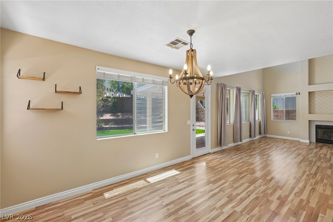 1727 Millstream Way Henderson, NV 89074 - Photo 14 of 46 Laminated flooring and a statement chandelier define this inviting living area.