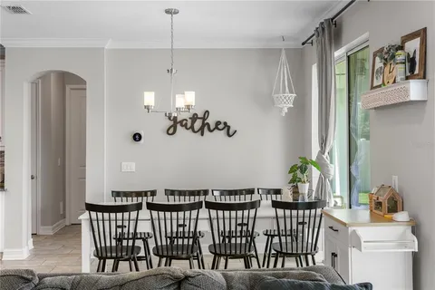 a kitchen with stainless steel appliances kitchen island granite countertop a dining table chairs and white cabinets