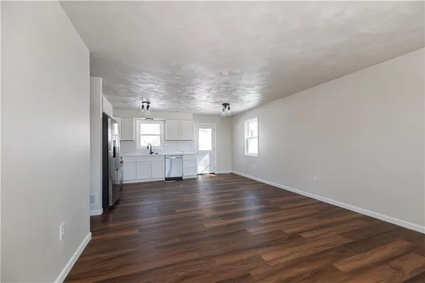 a kitchen with granite countertop a refrigerator and wooden floor