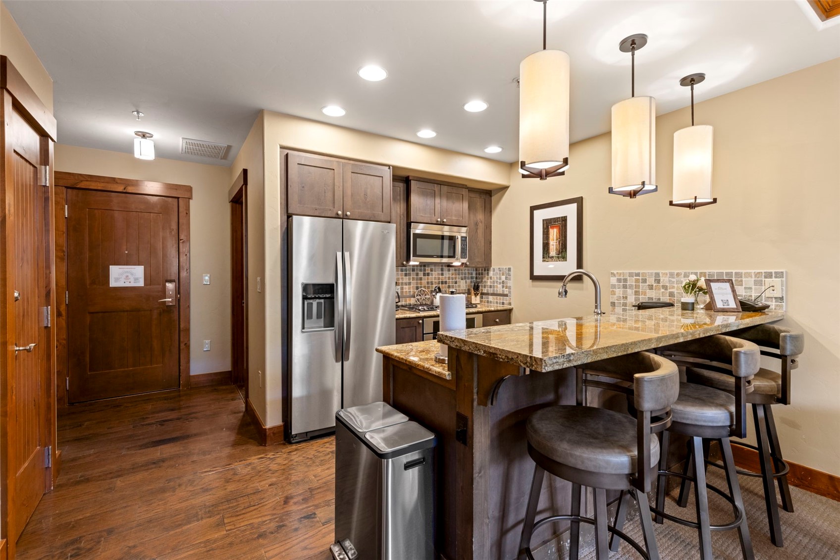 1521 Ski Hill Road, Unit 8313 Breckenridge, CO 80424 - Photo 20 of 45 a kitchen with granite countertop a table chairs stainless steel appliances and cabinets