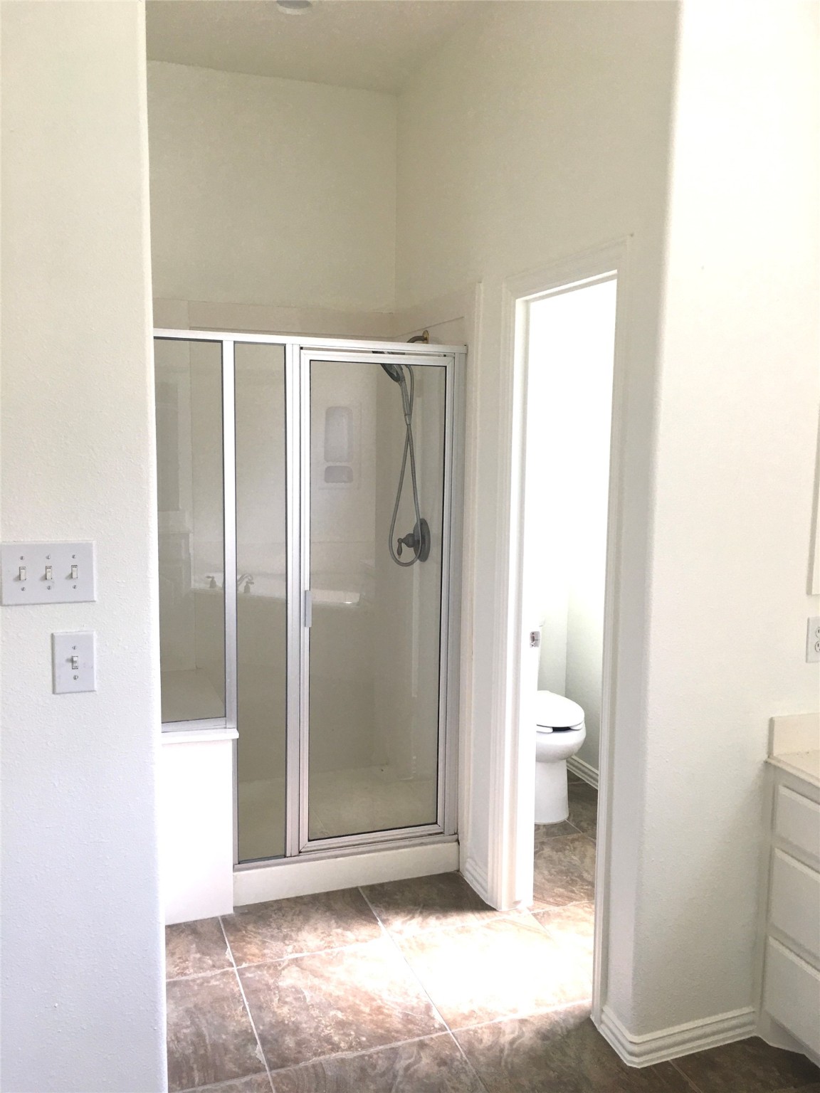 10730 Sea Myrtle Drive Houston, TX 77095 - Photo 26 of 36 a bathroom with a granite countertop toilet and a shower