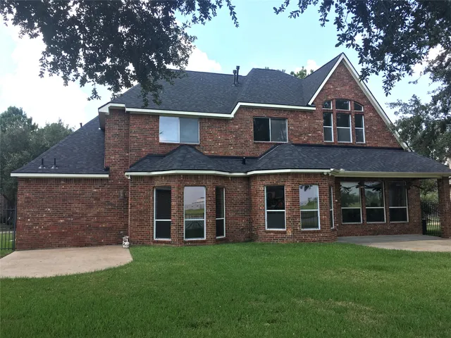 an empty room with wooden floor chandelier and windows