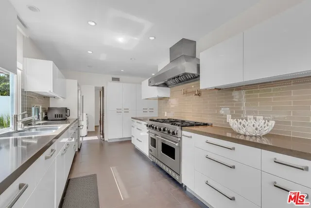 a large kitchen with stainless steel appliances granite countertop a lot of counter space and a sink