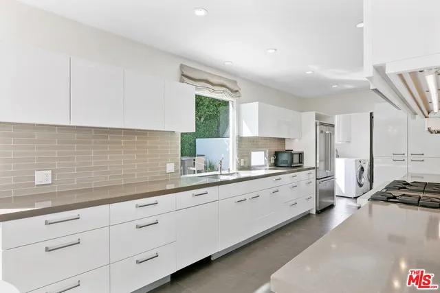 a kitchen with stainless steel appliances a sink and a stove top oven
