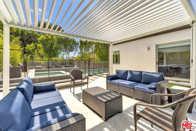a living room with a bed furniture and a flat screen tv