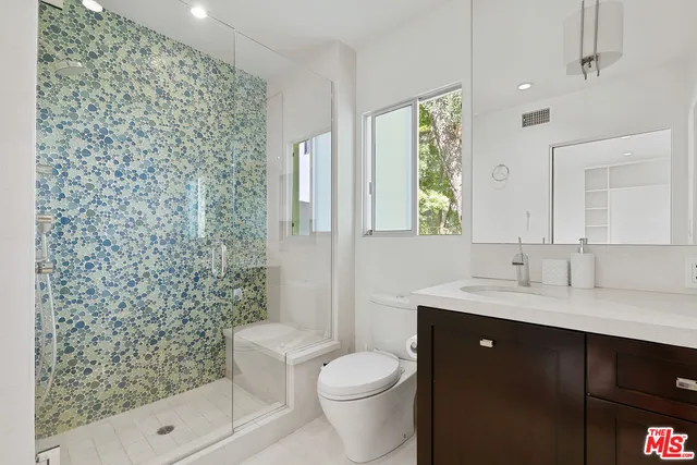 a front view of a house with a yard and potted plants