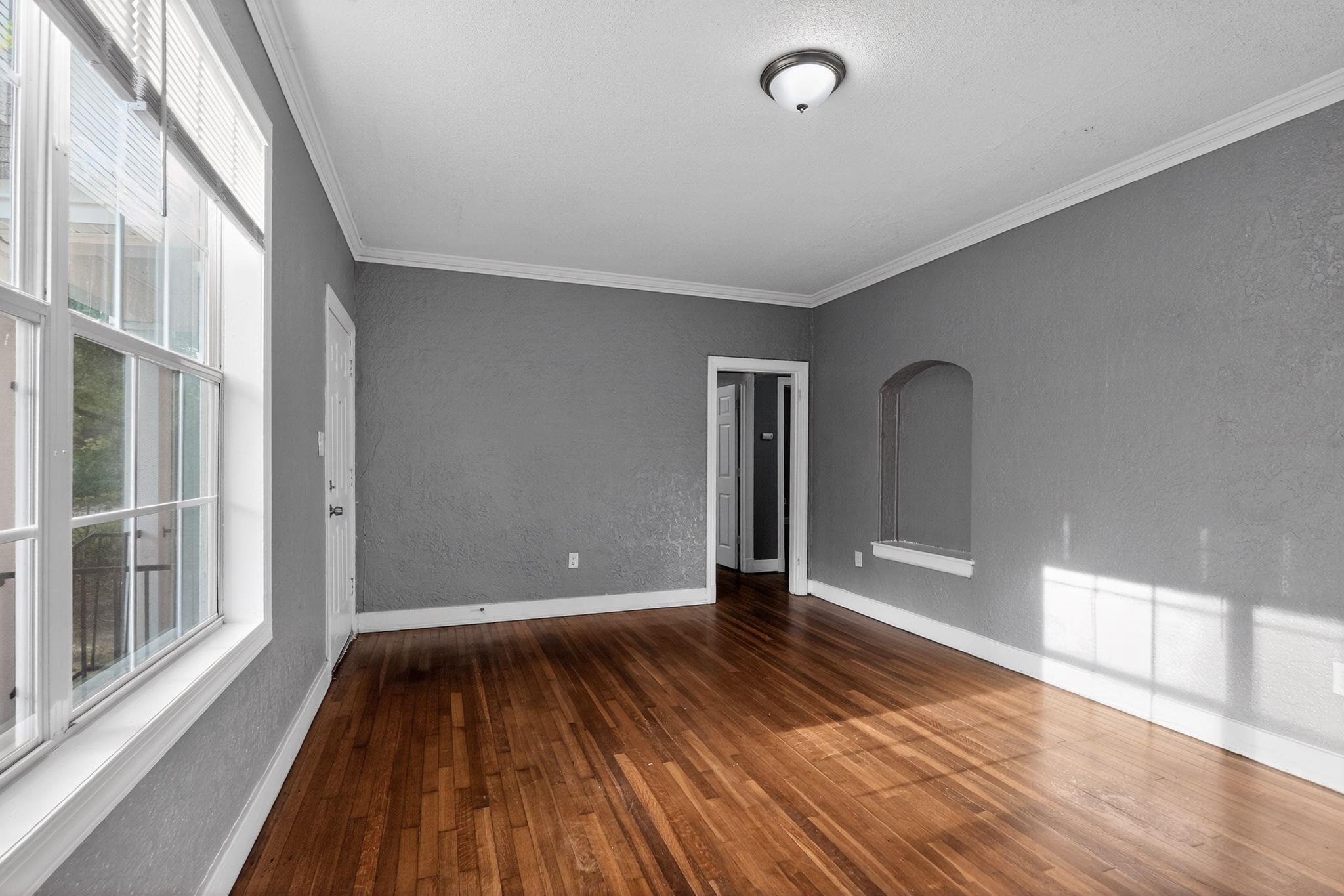 4199 Auburn Road Memphis, TN 38116 - Photo 13 of 32 Spacious room featuring rich wood-finish flooring, textured gray walls, and white crown molding
