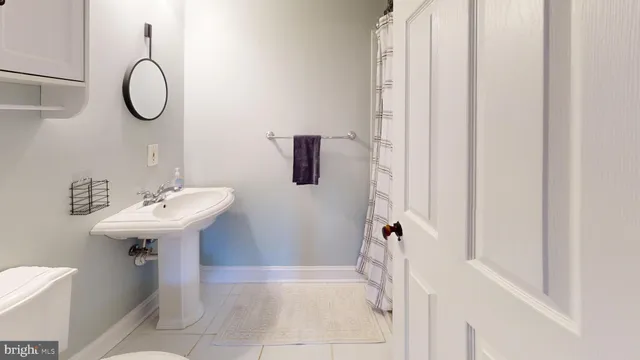 a bed sitting in a bedroom next to a window and a chandelier