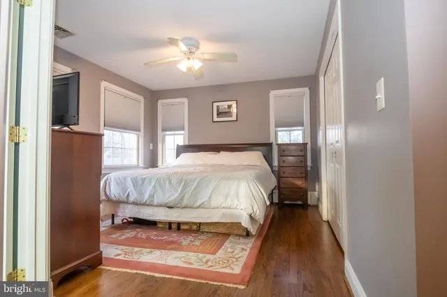 a bed sitting in a bedroom next to a window and a chandelier
