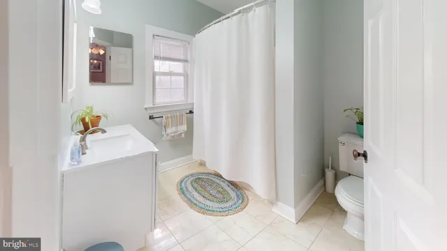 a bathroom with a sink a toilet and shower curtain