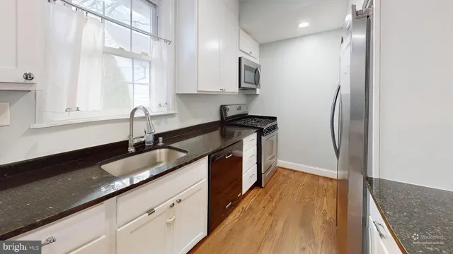a kitchen with kitchen island a sink appliances and cabinets