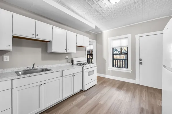 a kitchen with granite countertop white cabinets and white appliances