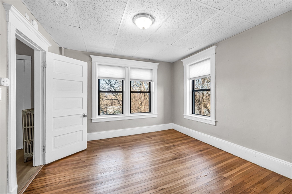 92 Woodside Terrace, Unit 2R Springfield, MA 01108 - Photo 14 of 42 an empty room with wooden floor and windows