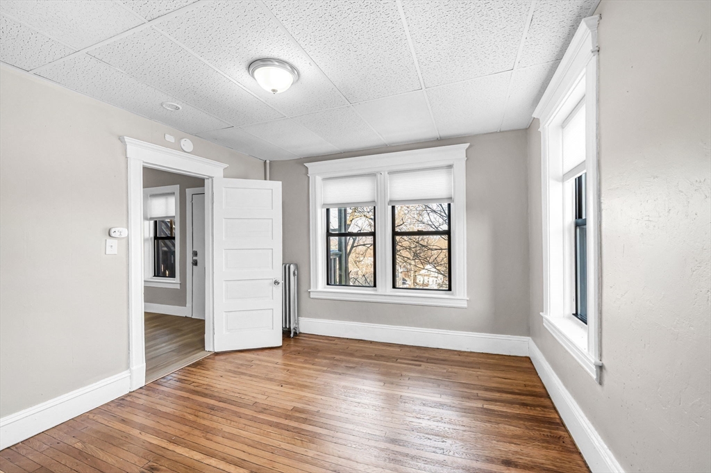 92 Woodside Terrace, Unit 2R Springfield, MA 01108 - Photo 15 of 42 an empty room with wooden floor and windows