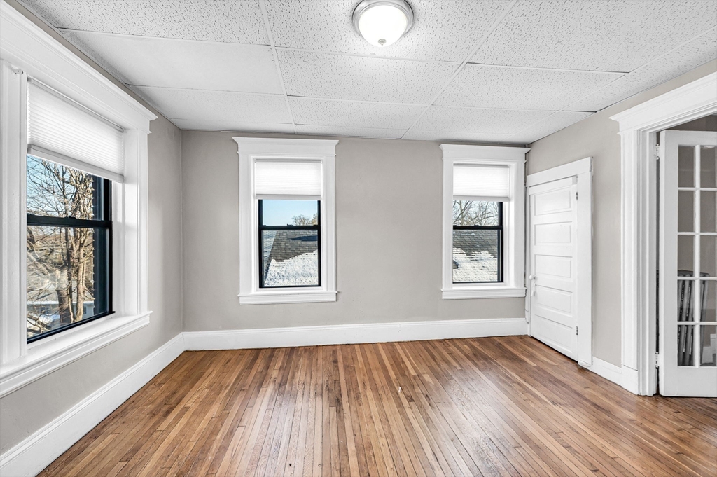 92 Woodside Terrace, Unit 2R Springfield, MA 01108 - Photo 18 of 42 an empty room with wooden floor and windows