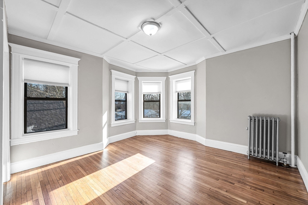 92 Woodside Terrace, Unit 2R Springfield, MA 01108 - Photo 19 of 42 a view of an empty room with wooden floor and a window
