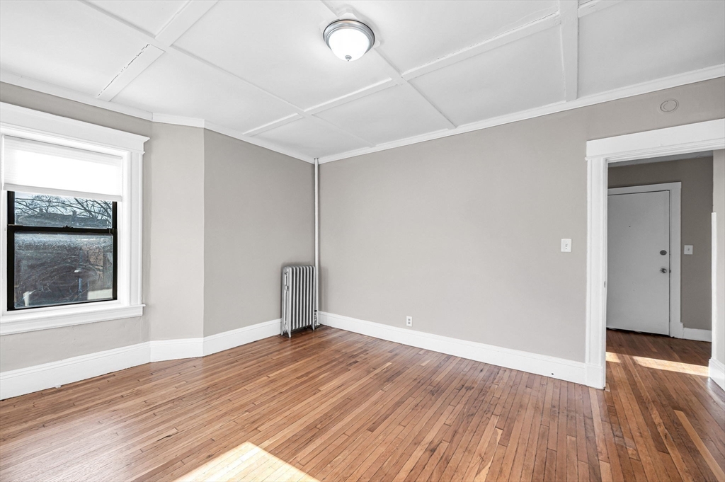 92 Woodside Terrace, Unit 2R Springfield, MA 01108 - Photo 21 of 42 an empty room with wooden floor and windows