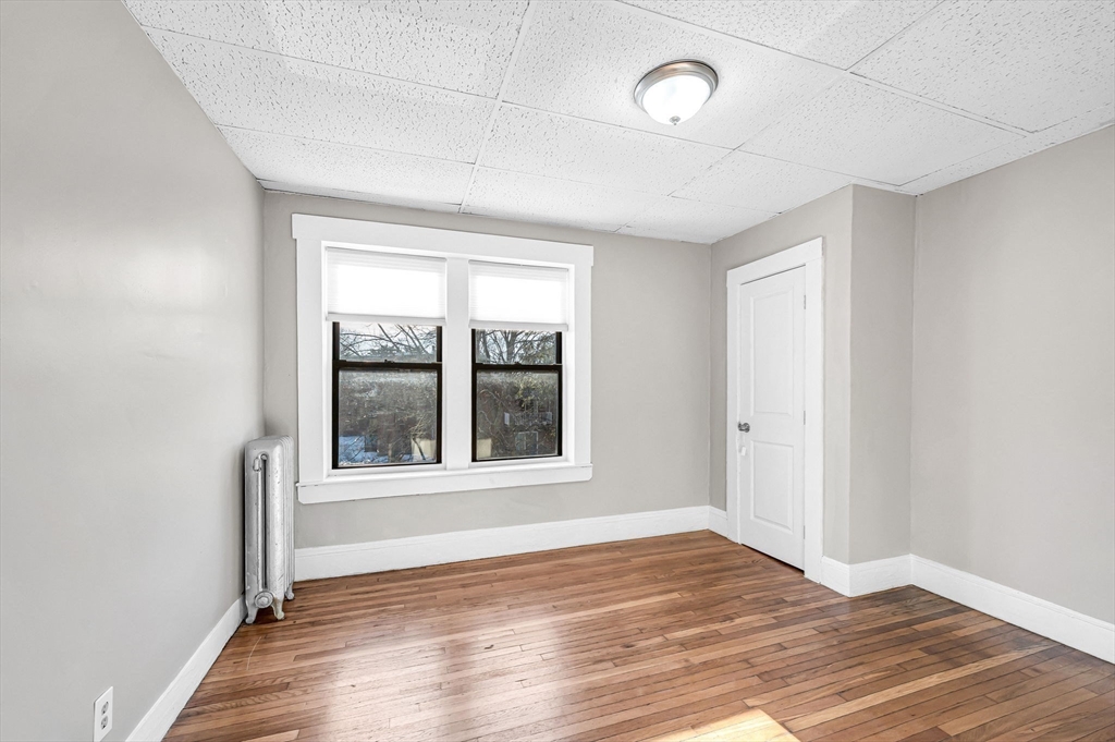 92 Woodside Terrace, Unit 2R Springfield, MA 01108 - Photo 24 of 42 a view of an empty room with wooden floor and a window