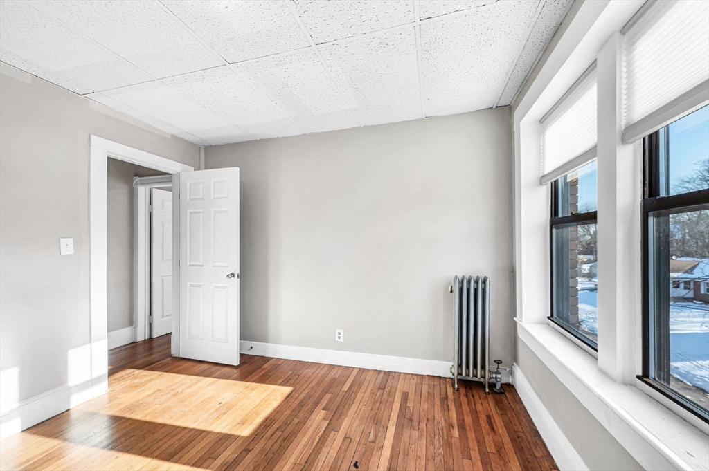 92 Woodside Terrace, Unit 2R Springfield, MA 01108 - Photo 27 of 42 a view of an empty room with a window and wooden floor