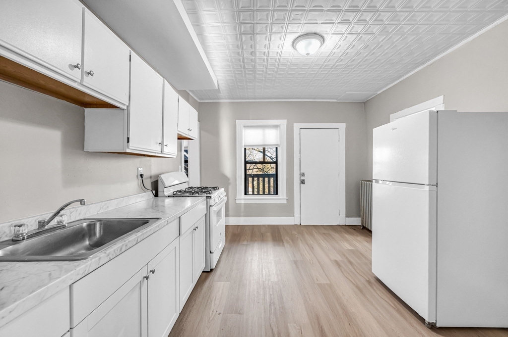 92 Woodside Terrace, Unit 2R Springfield, MA 01108 - Photo 4 of 42 a kitchen with a sink a refrigerator and cabinets