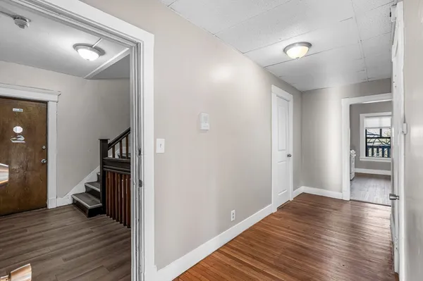a view of a hallway with wooden floor and a bedroom