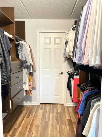 a view of walk in closet with clothes and shoes