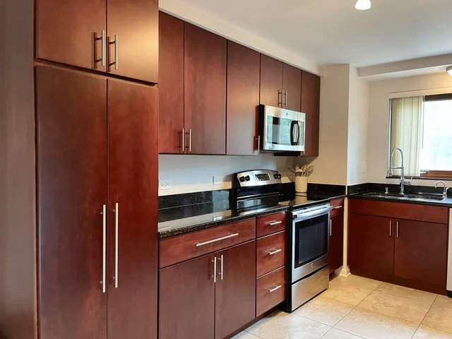 a kitchen with stainless steel appliances granite countertop cabinets and refrigerator
