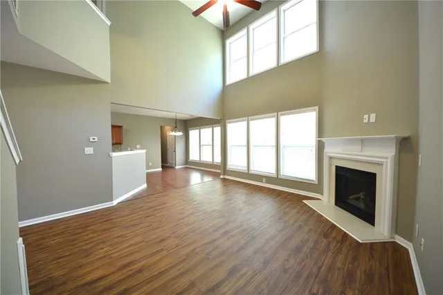 a view of an empty room with window and wooden floor