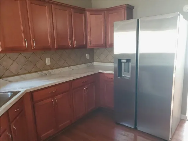 a kitchen with stainless steel appliances granite countertop a refrigerator and a sink
