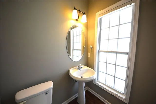 a bathroom with a toilet sink and mirror