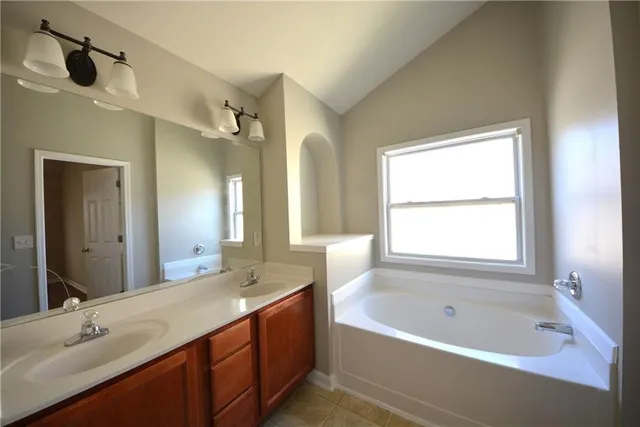 a bathroom with a tub sink and a mirror