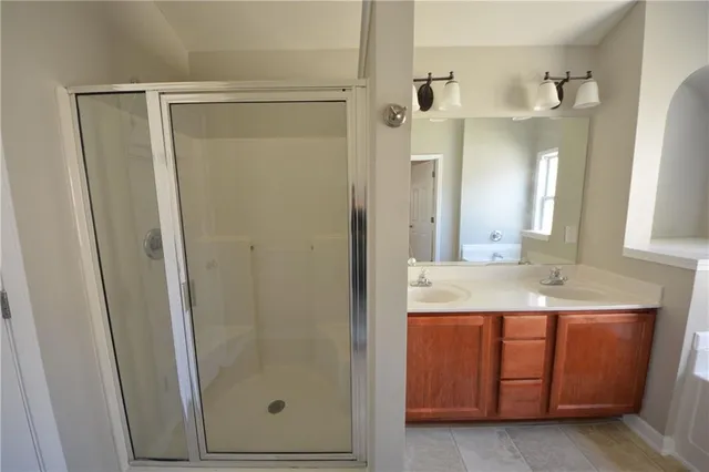 a bathroom with a shower a sink and a mirror