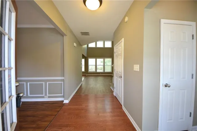 a view of a hallway with wooden floor and entryway