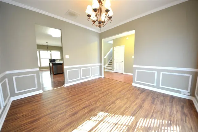 a view of a room with wooden floors and chandelier