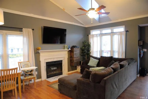 a living room with furniture a flat screen tv and a fireplace