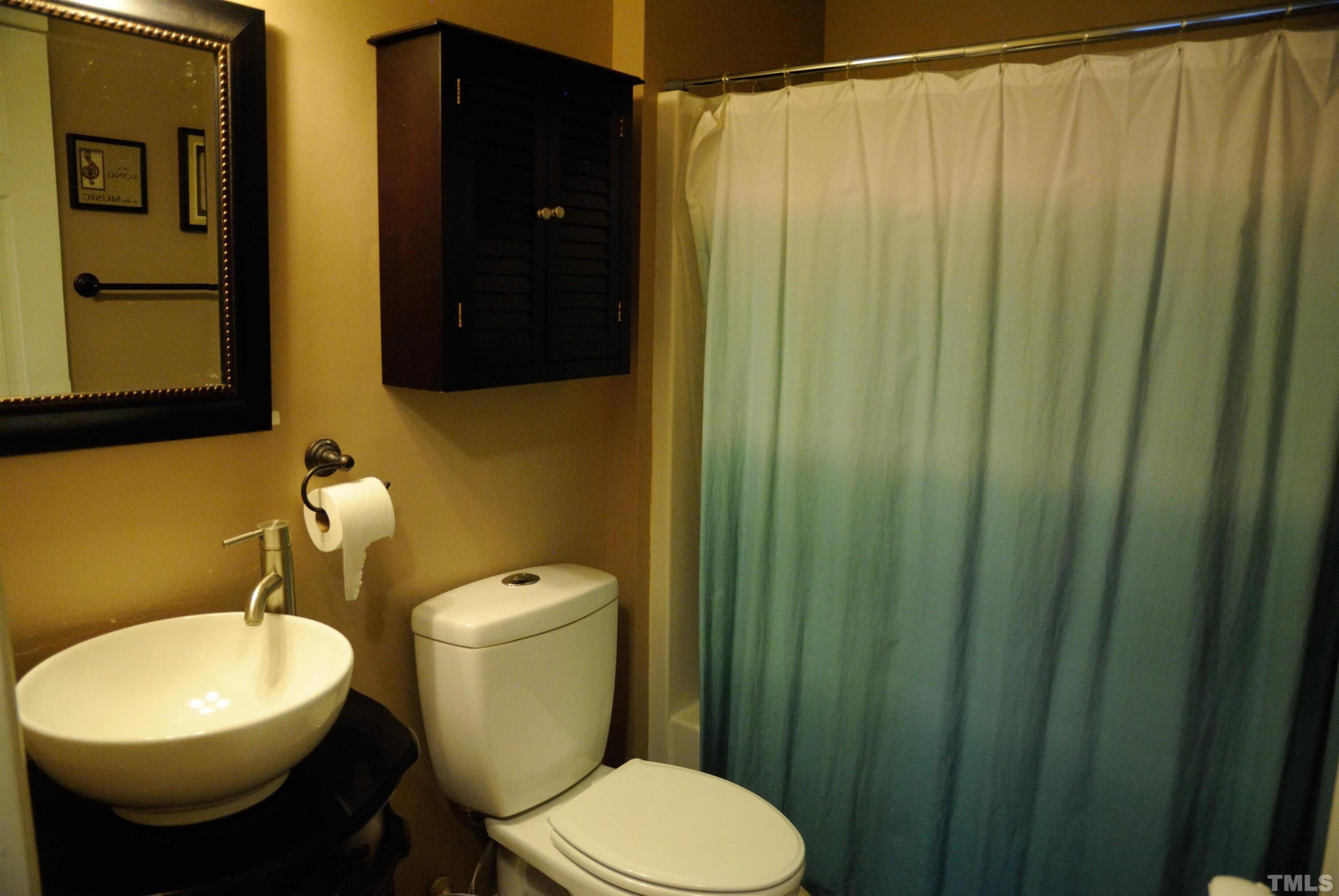 4125 Cobble Court Raleigh, NC 27616 - Photo 10 of 12 a bathroom with a toilet a sink and a shower