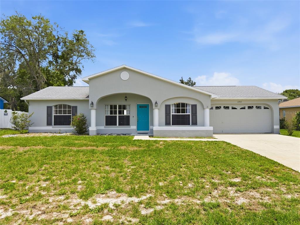 2202 Godfrey Avenue Spring Hill, FL 34609 - Photo 5 of 36 a front view of a house with a garden