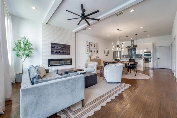 a living room with furniture kitchen view and a chandelier
