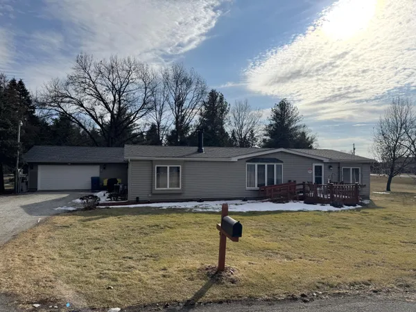 a front view of house with yard seating and covered with trees
